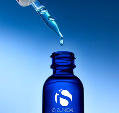 Blue dropper bottle with a droplet of liquid against a blue background, featuring the 'IS Clinical' logo.