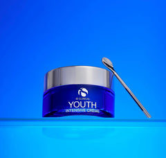 Blue jar of 'Youth Intensive Creme' with a silver applicator on a blue background