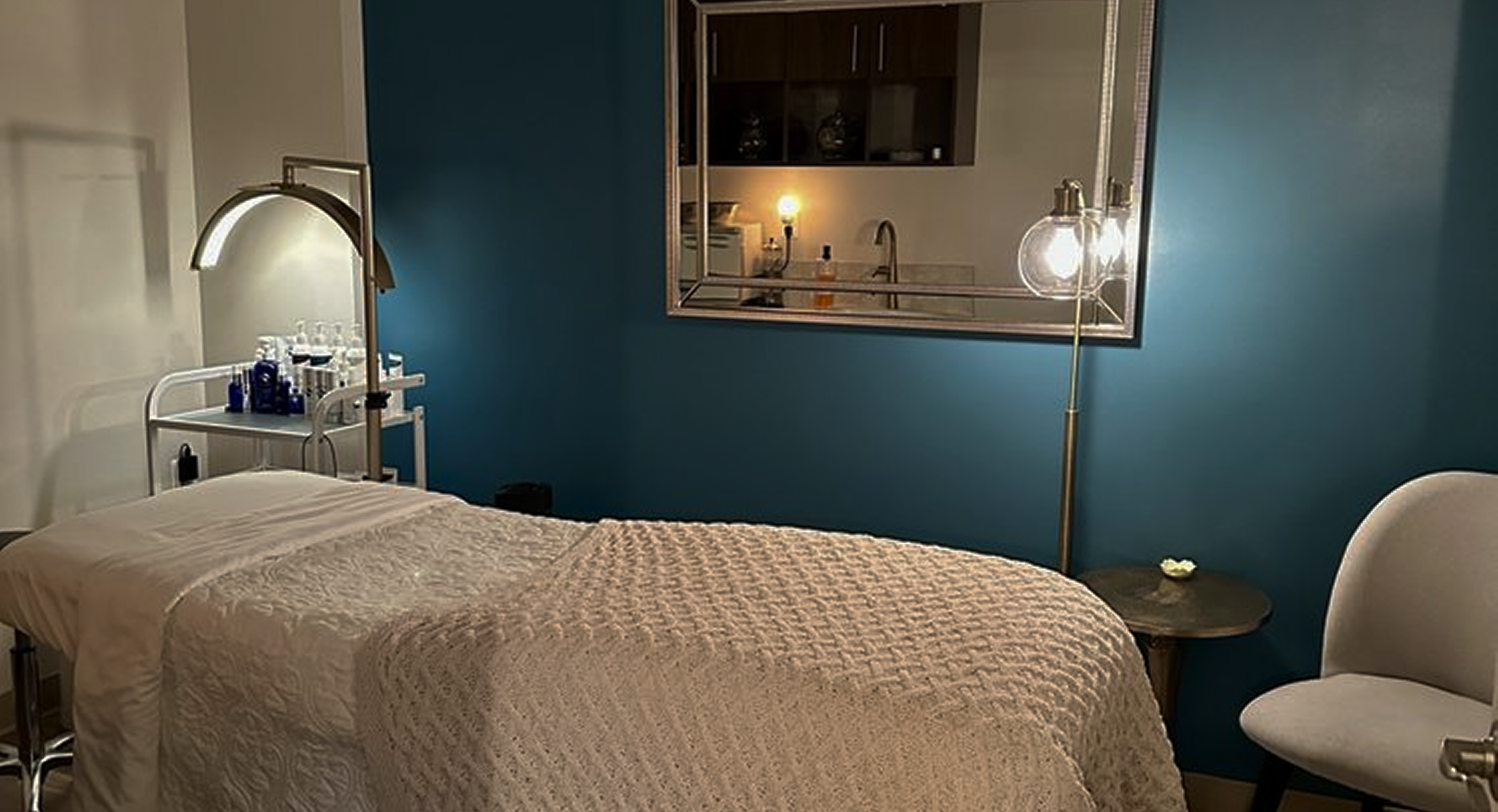 Bedroom with blue walls, a bed, and a chair.