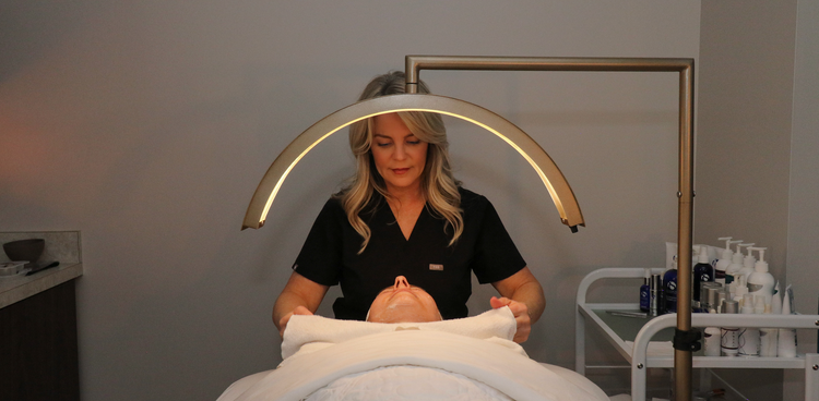 Person receiving a treatment under a LED light in a clinical setting