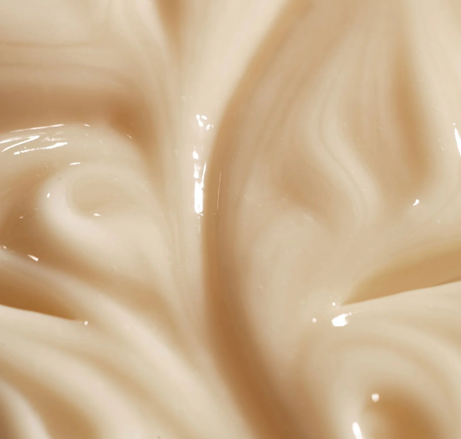 Close-up of smooth, beige-colored cream or milk texture