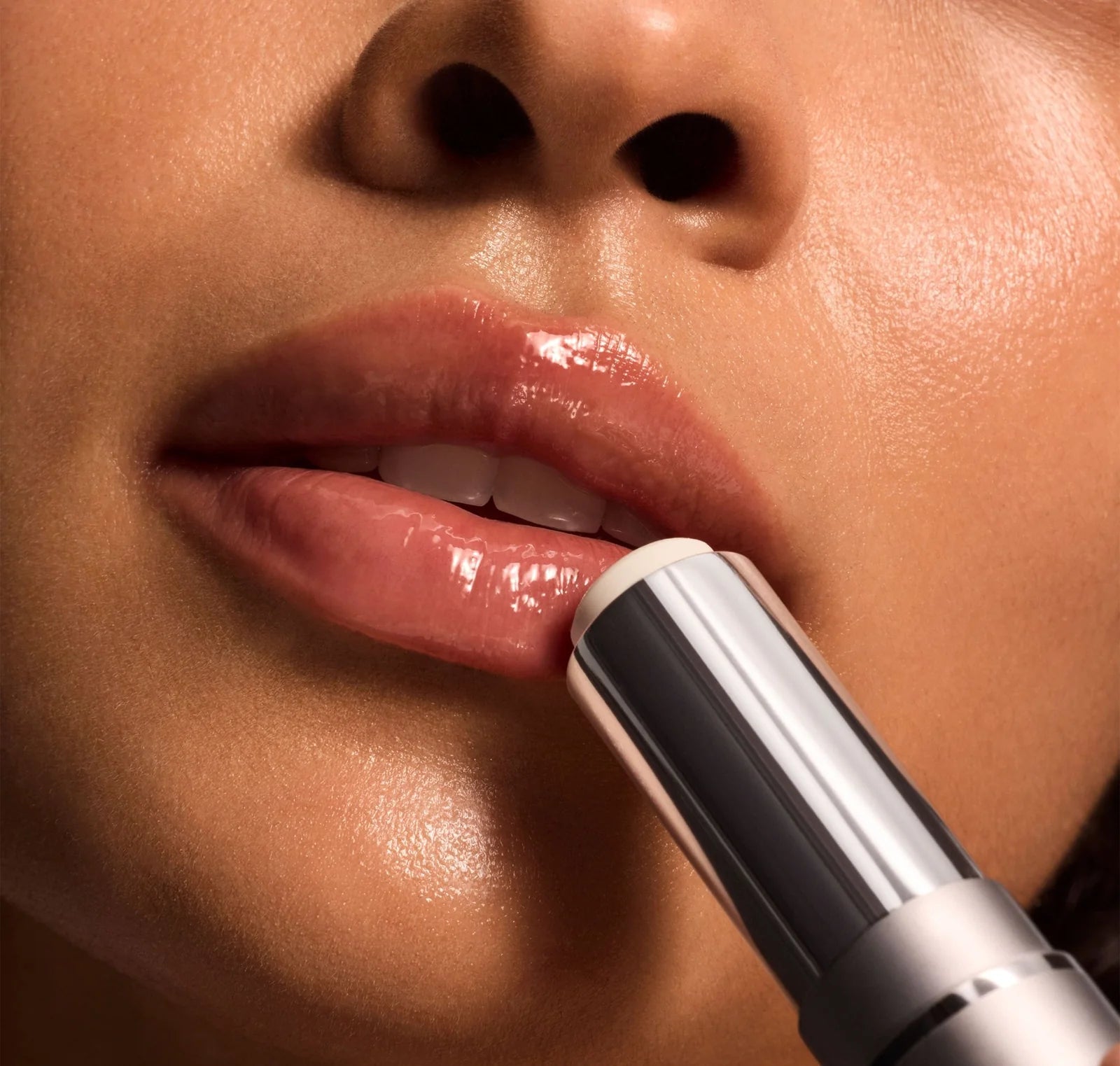 Close-up of a person applying lipstick with a focus on the lips and lipstick.