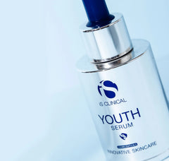 IS Clinical Youth Serum bottle on a light blue background